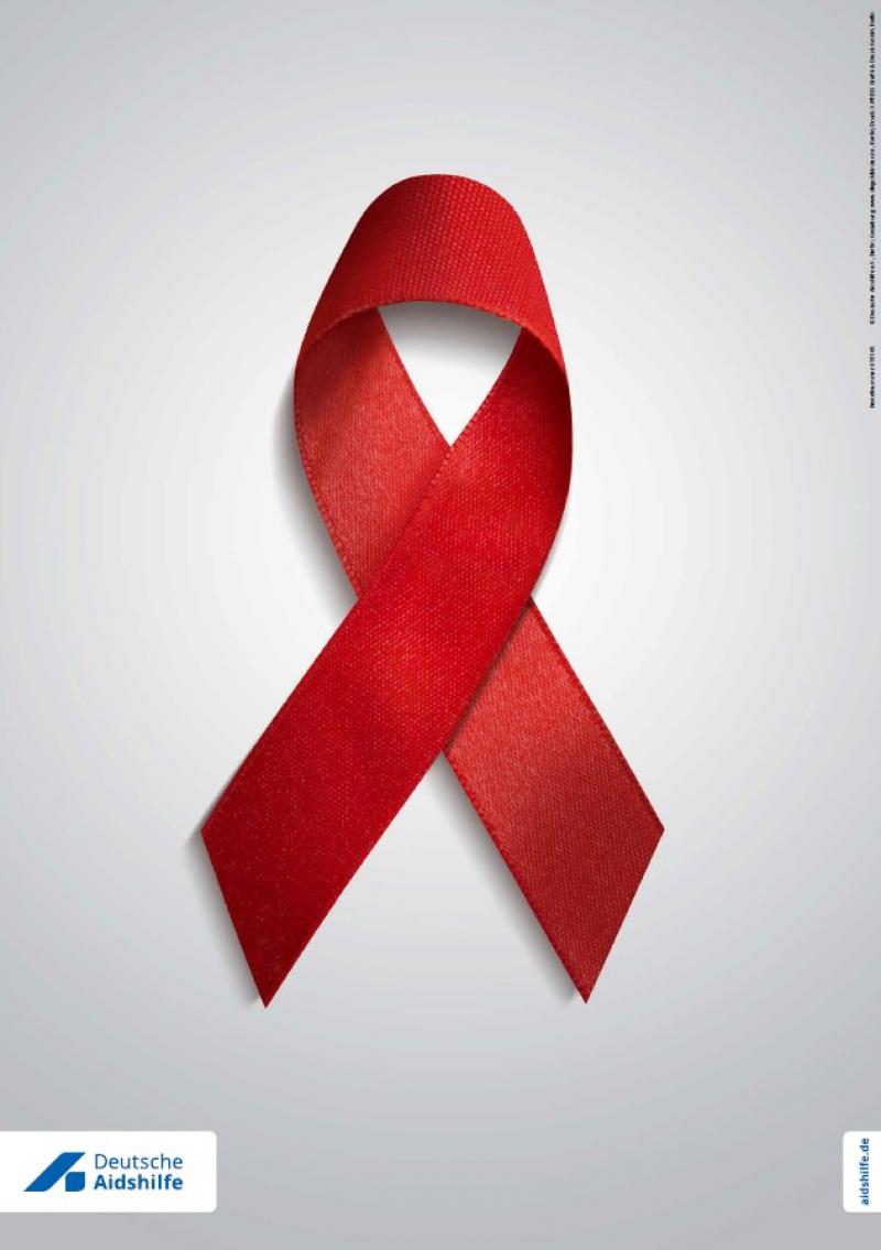 Rote Aids-Schleife auf grauem Hintergrund.