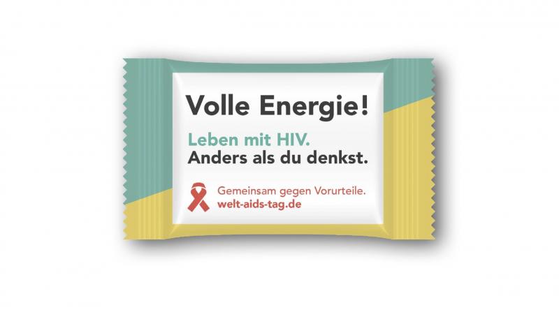 Bild der Verpackung. Grün und gelb. Aufdruck "Welt Aids Tag" "Volle Energie"