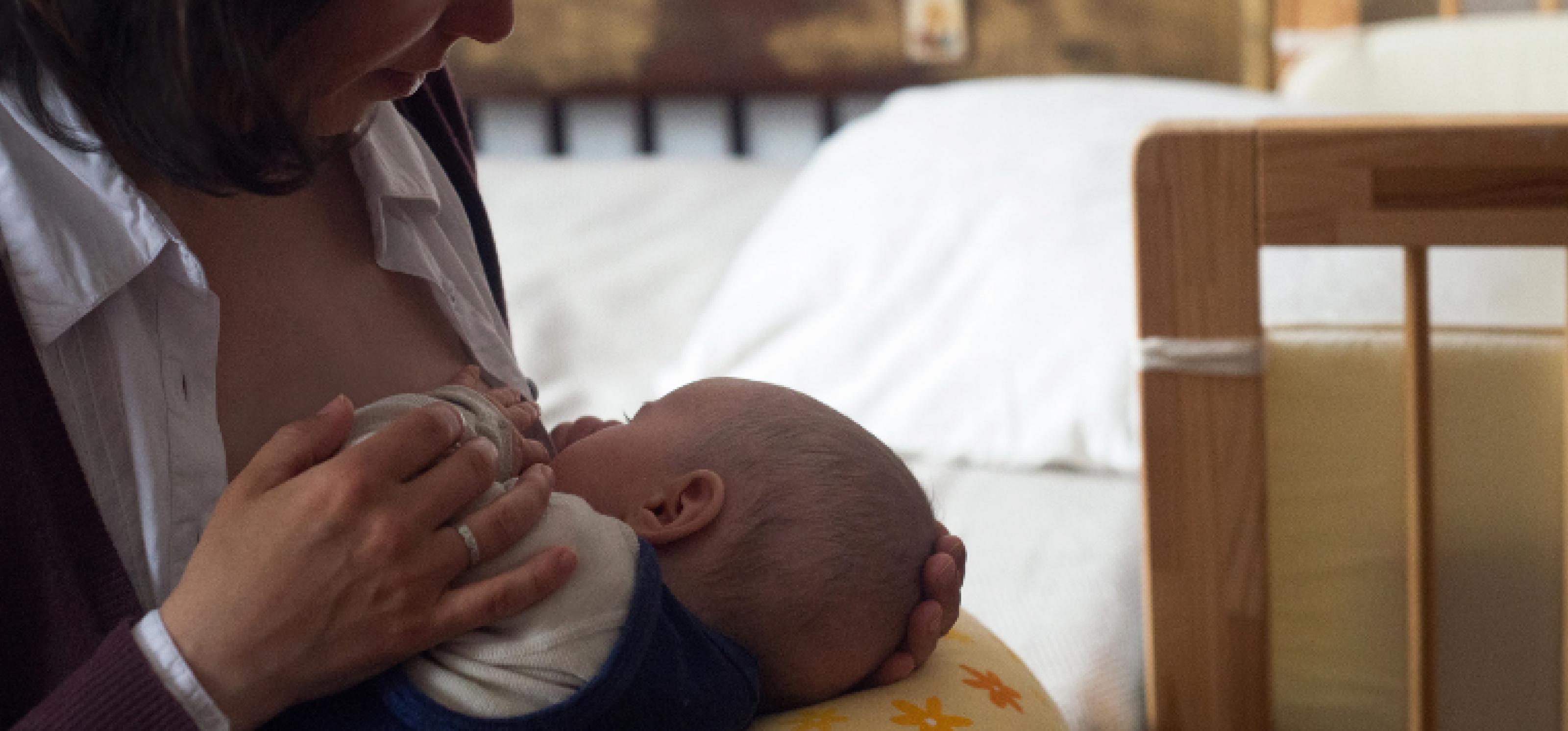 Eine stillende Mutter mit einem Baby an der Brust zur Illustration von Kinderwunsch bei HIV