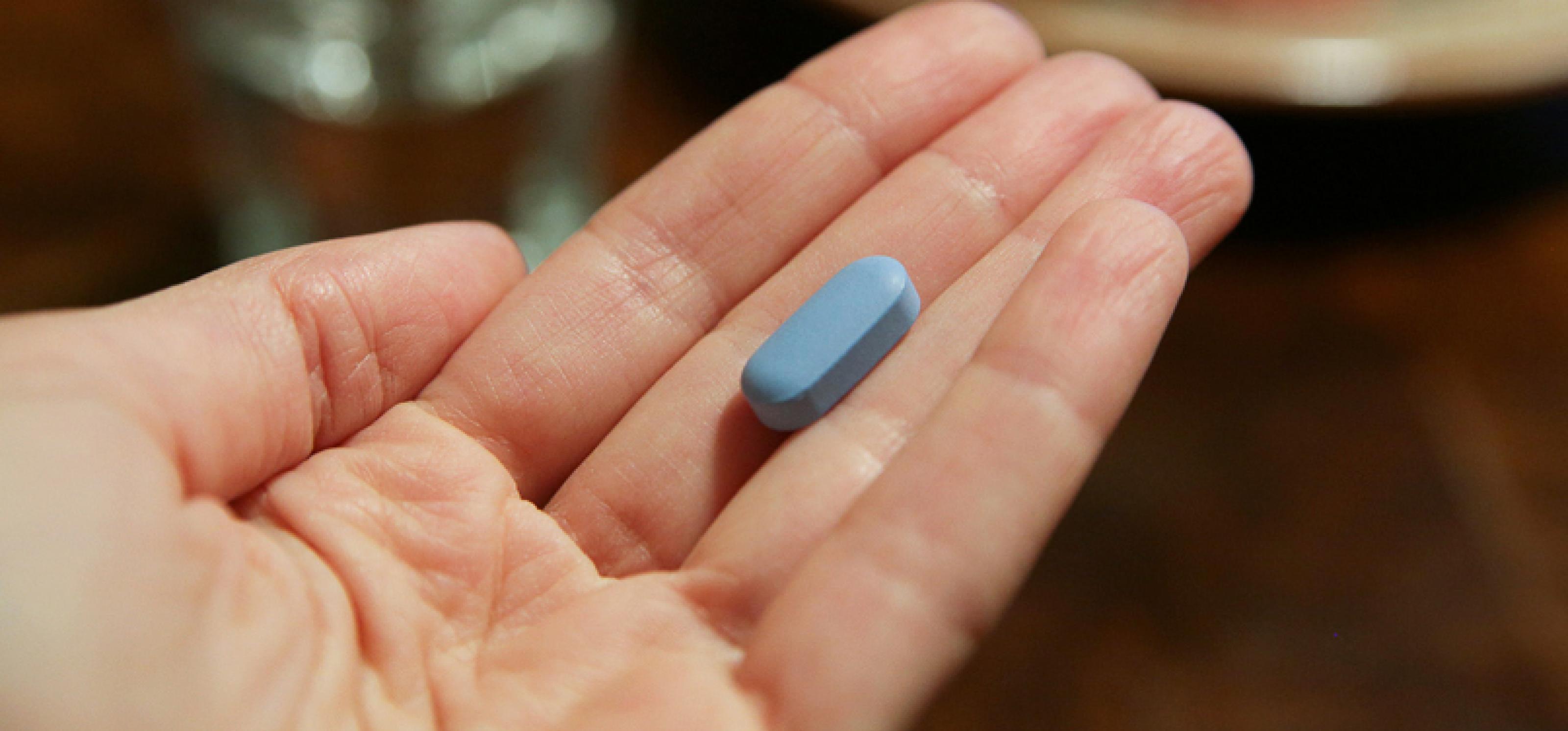 auf einer Handinnenfläche liegt eine blaue Pille