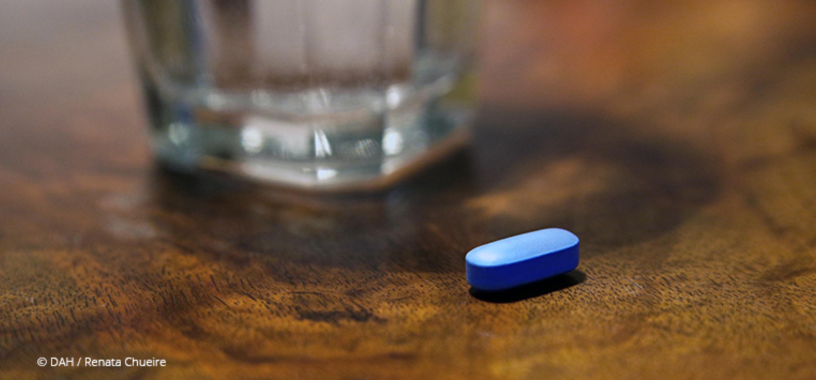 blaue Pille und ein Glas Wasser